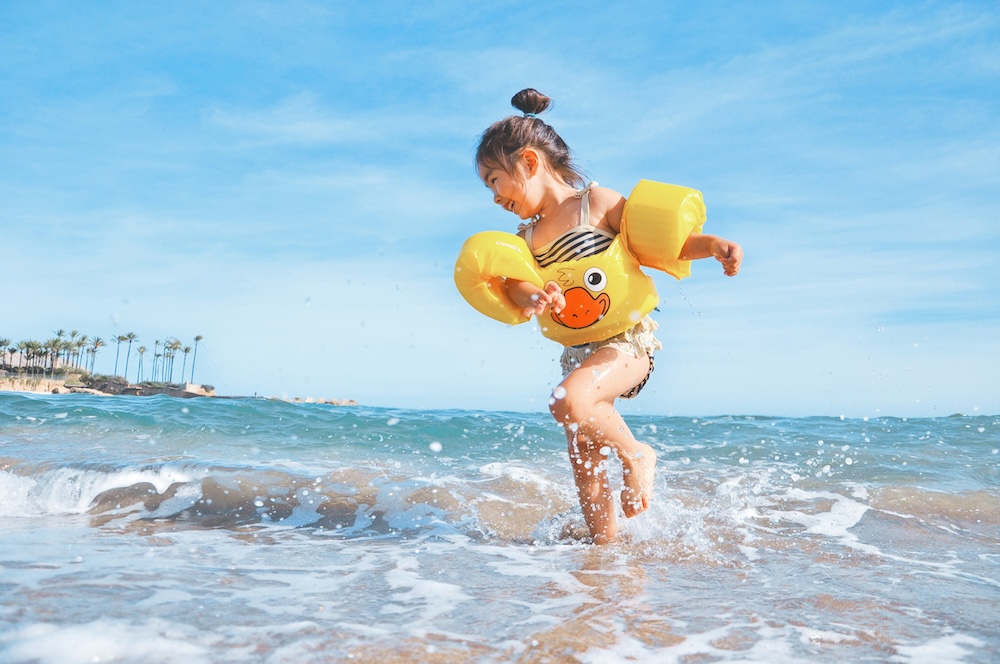 Child playing in the water on the beach